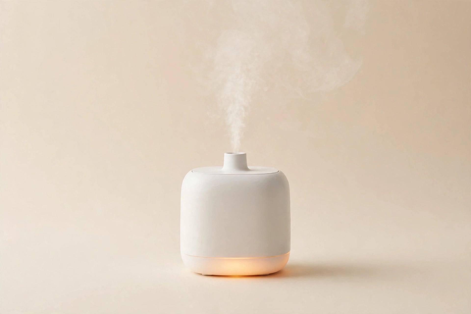 Small white generic humidifier with warm amber night glow on cream background